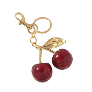 Cherry-shaped keychains with gold stem on a textured white surface- cherry purse charms