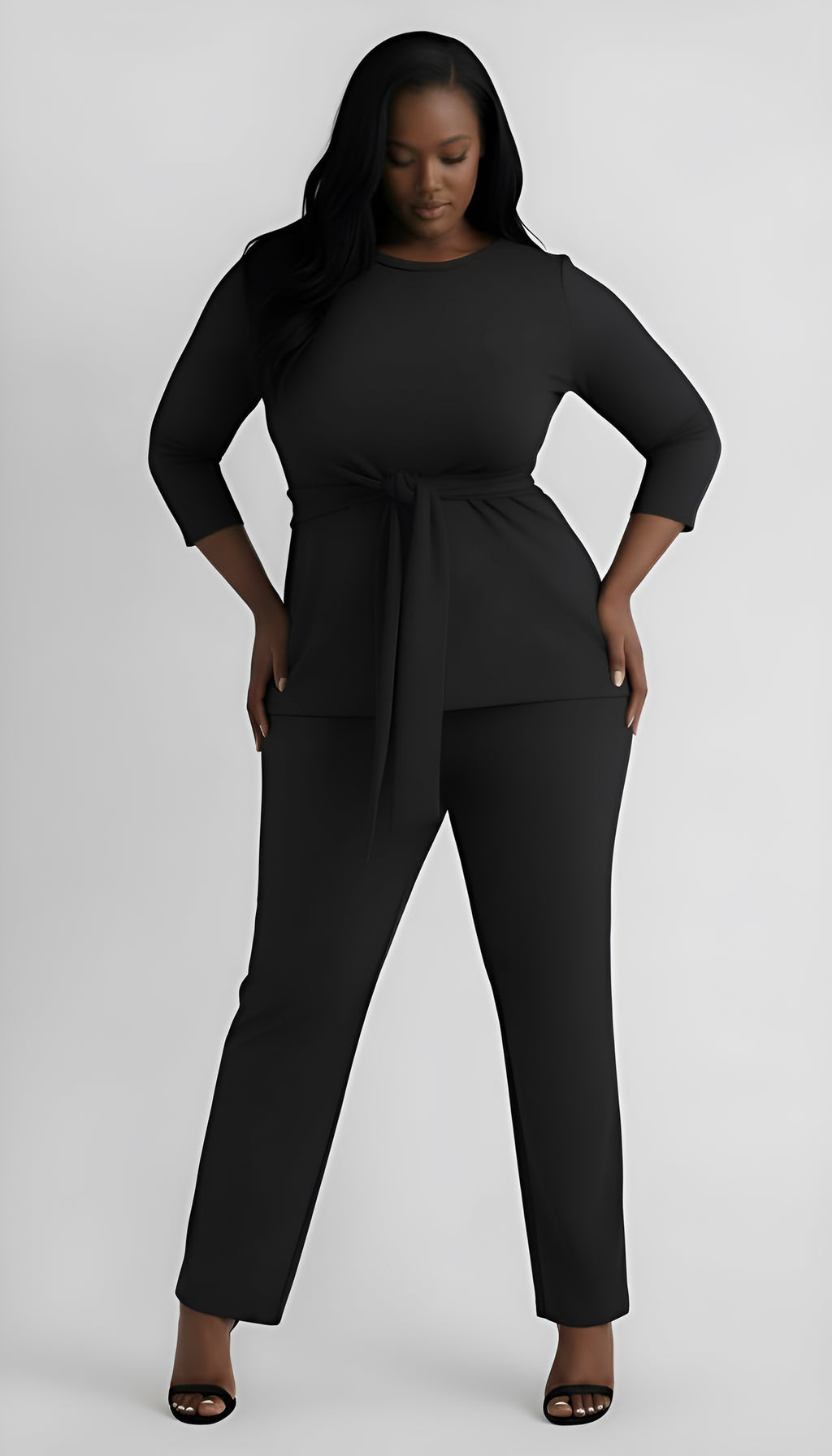 Woman wearing a black outfit with a tie waist on a white background