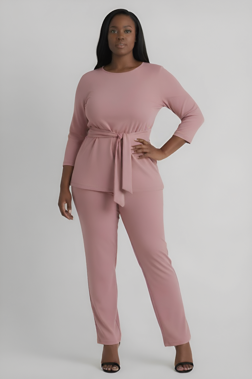 Woman wearing a pink outfit with a front tie on a white background