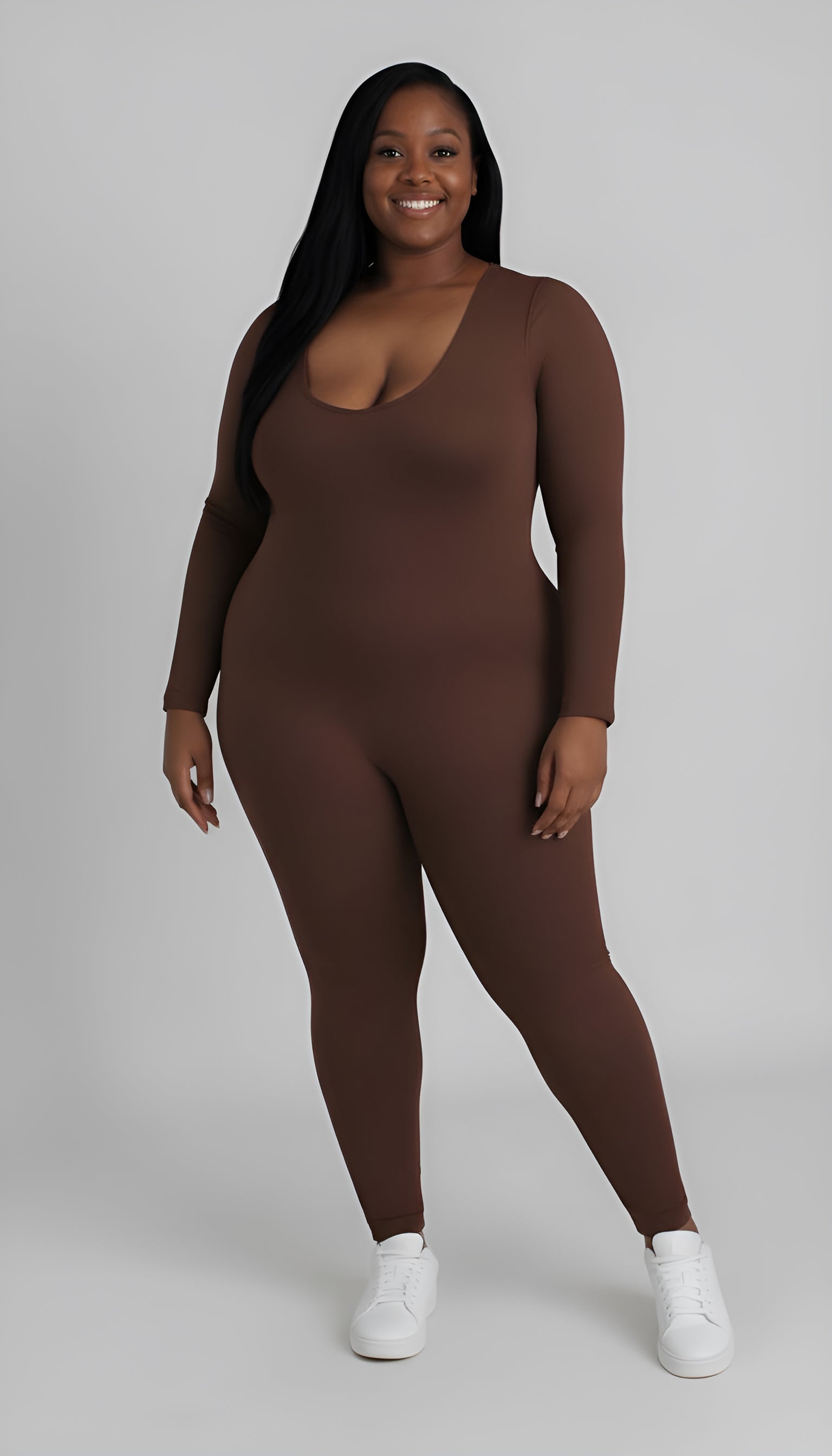 woman wearing a brown bodysuit on a plain background