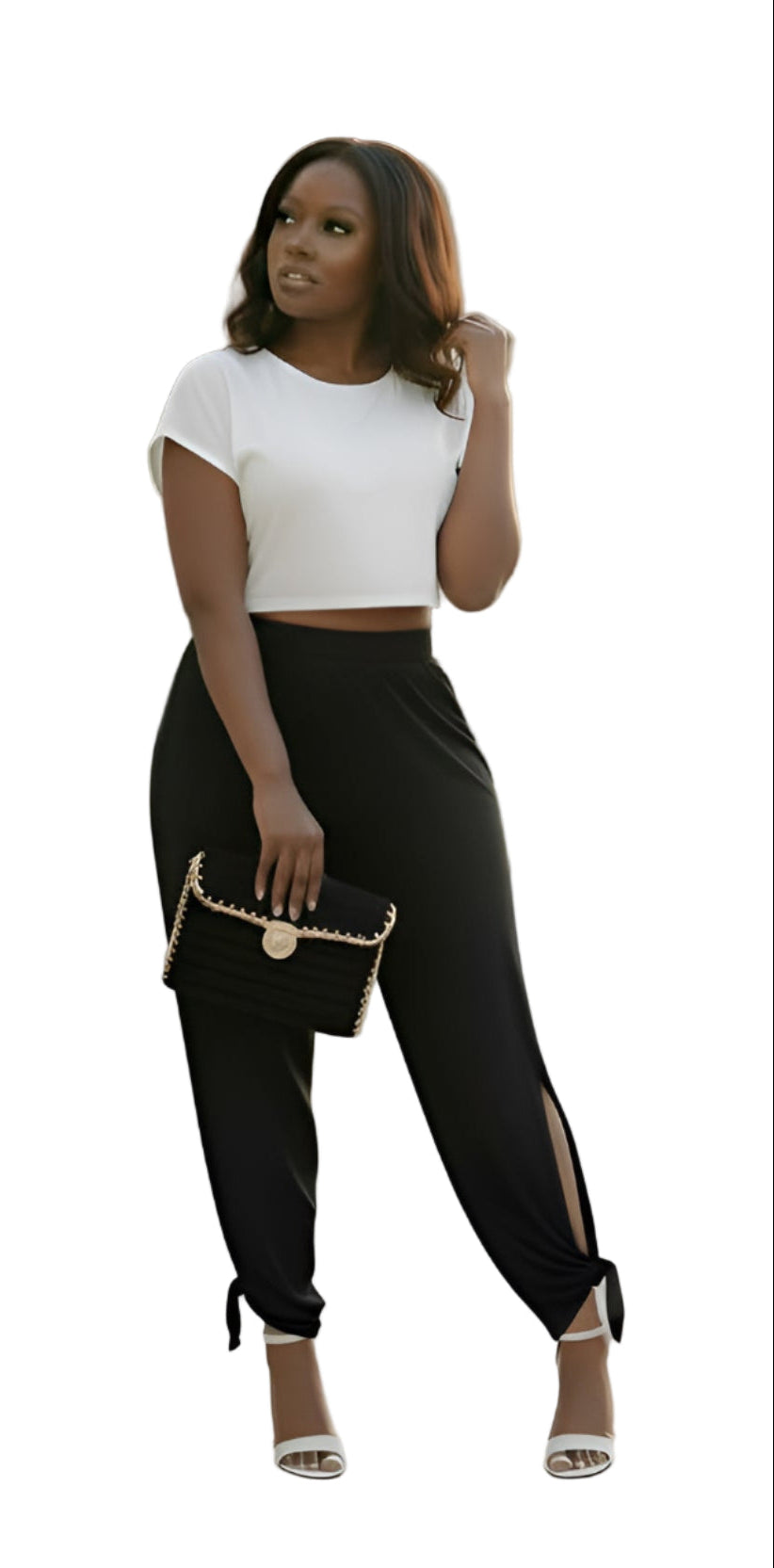 Woman wearing a white top and black pants with a gold and black clutch purse on a white background