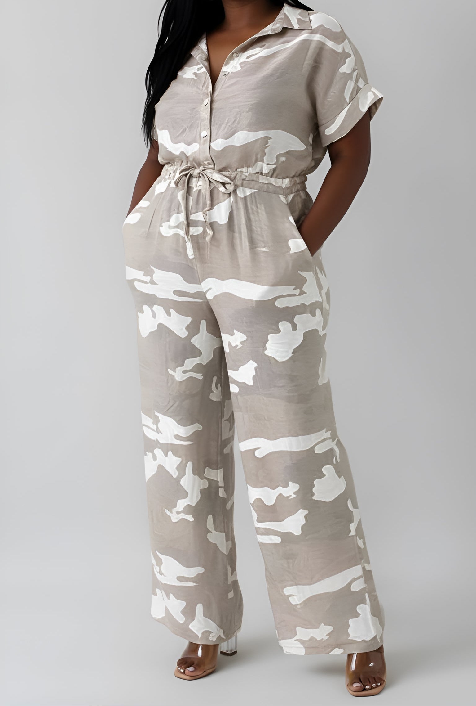 Camouflage jumpsuit worn by a woman showing pockets on a plain background