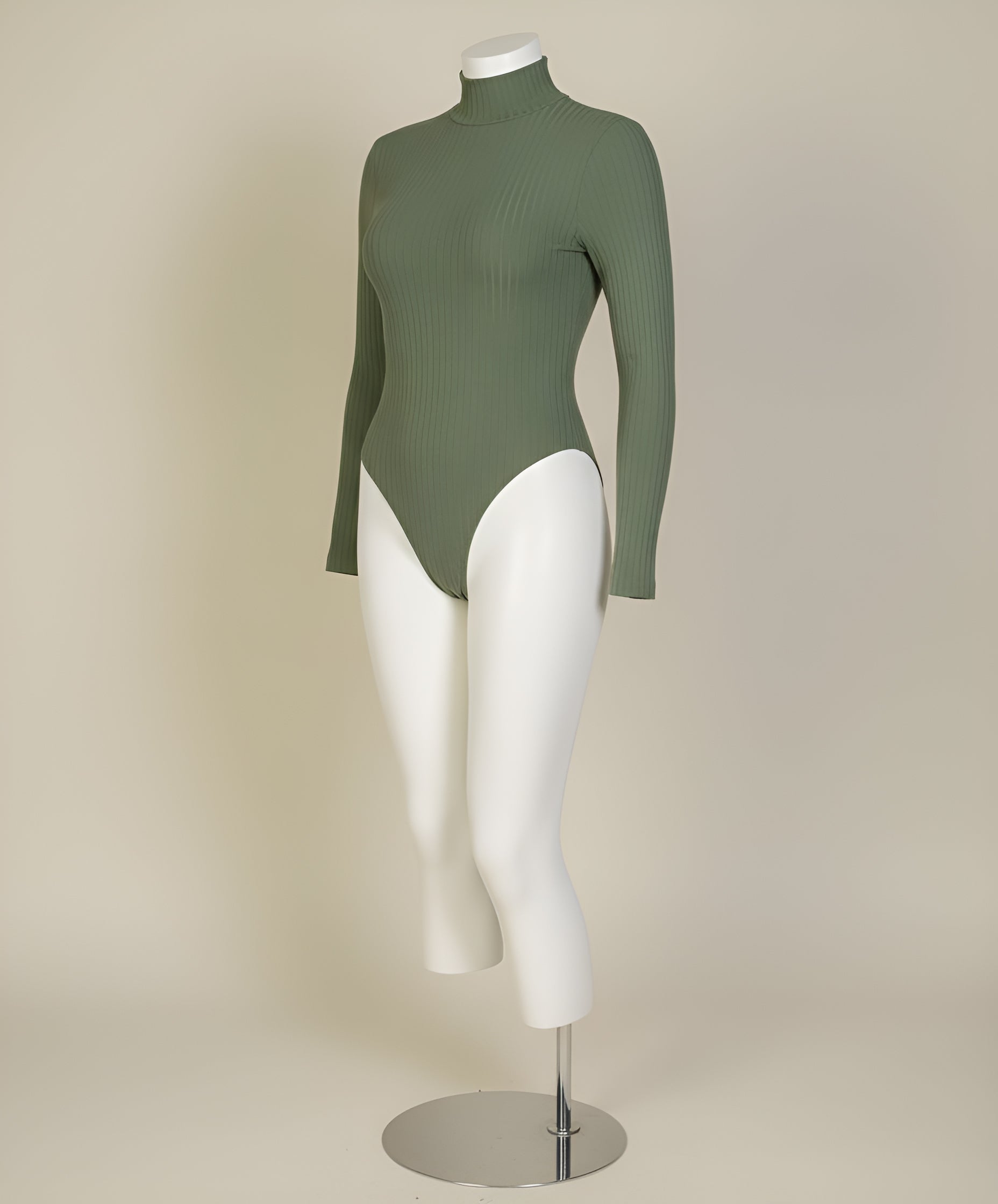 Green ribbed turtleneck bodysuit on a white mannequin against a beige background
